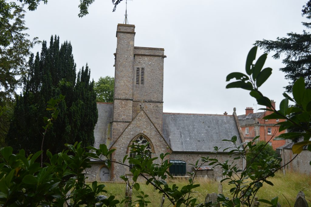 Wootton Fitzpaine Church from the road, showing the Manor House below